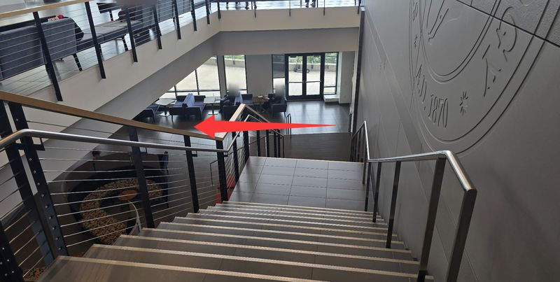 View down the staircase; a red arrow points left